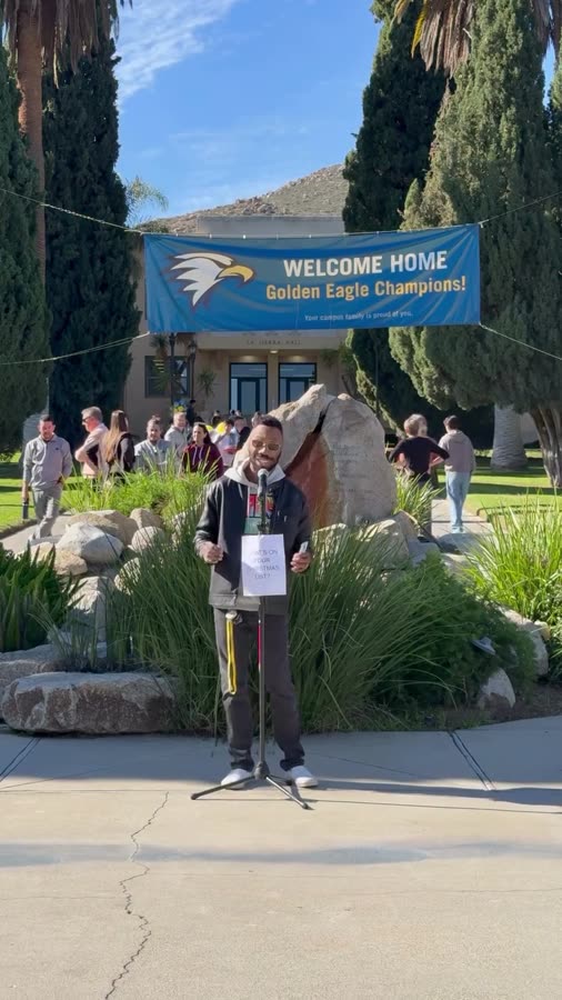 A student answers a prompt at a microphone on campus.